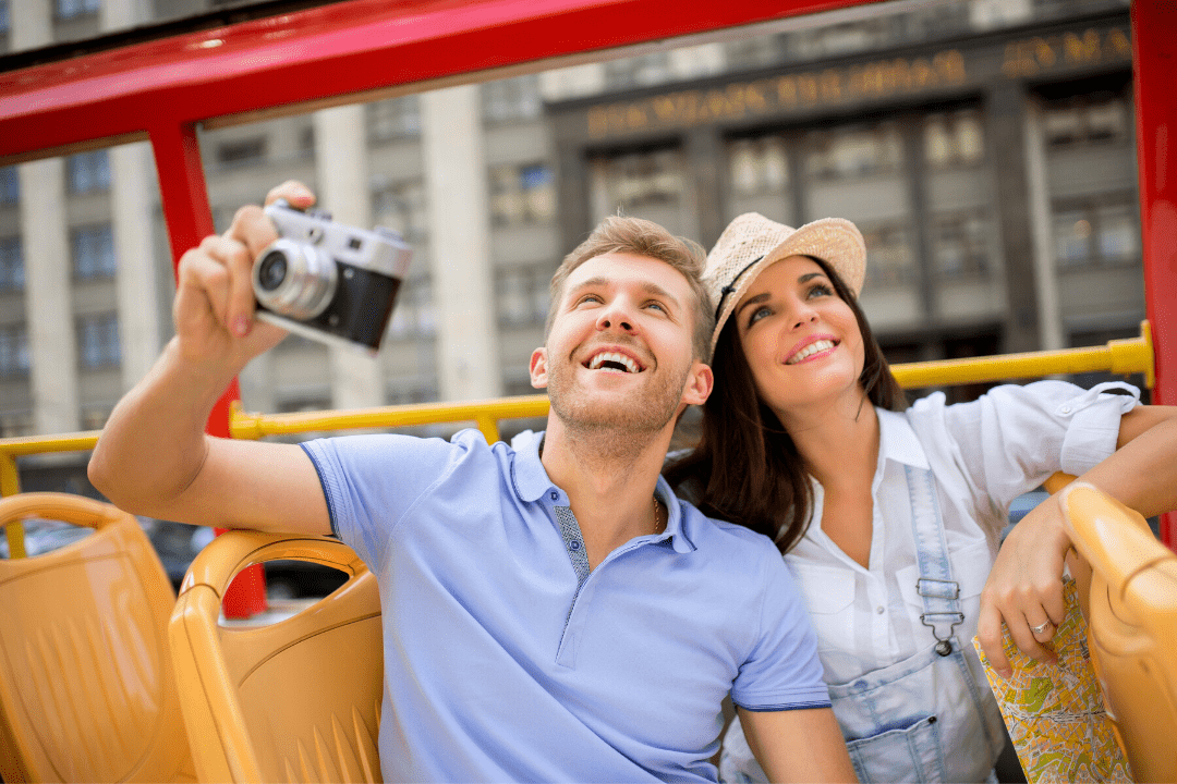 Mann und Frau sitzen im Bus mit Kamera in der Hand