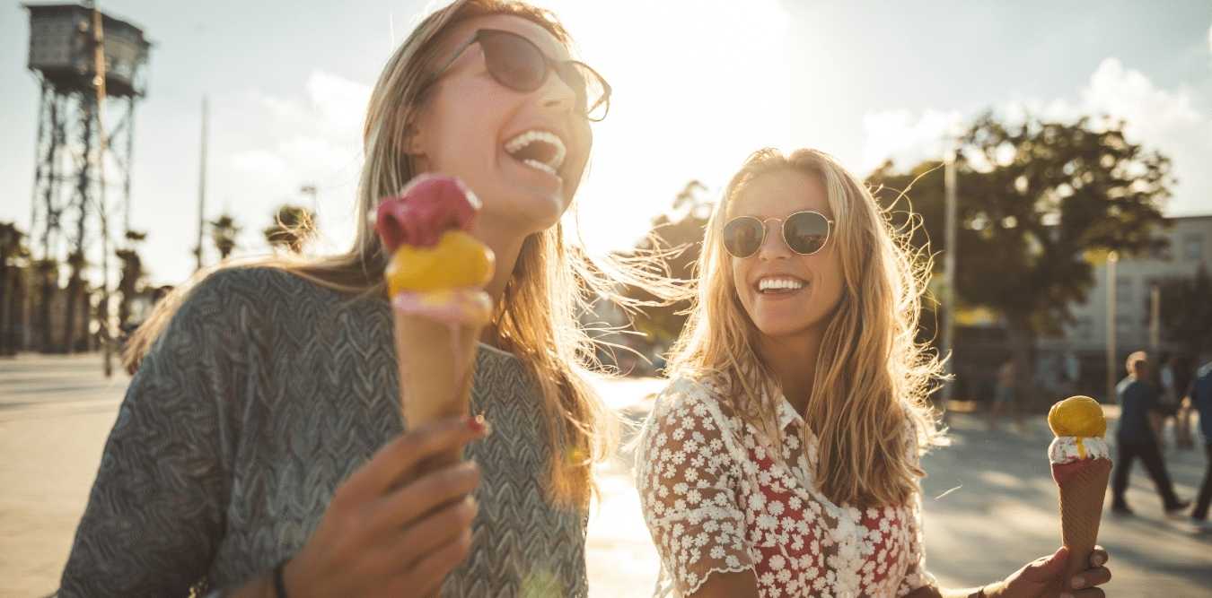 Zwei Frauen lachen mit Eis in der Hand