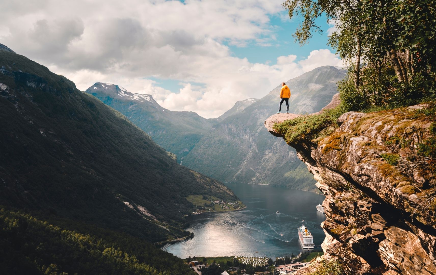 Mann auf Fels mit Blick auf norwegischen Fjord
