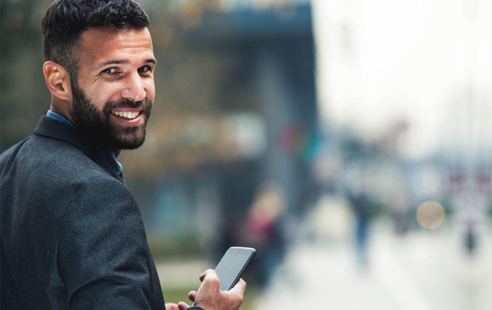 Voya Key Visual Lächelnder Geschäftmann mit Smartphone