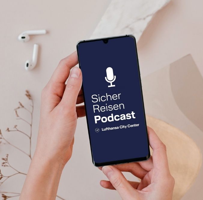 Smartphone mit dem LCC Sicher Reisen Podcast auf dem Display