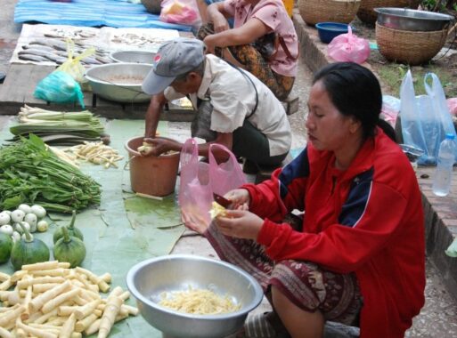 Einheimische schneidet Gemüse auf einem Markt