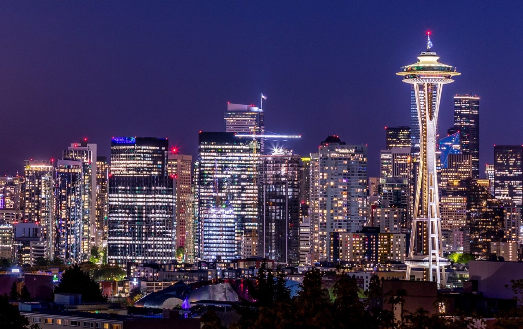 Seattle Space Needle beleuchtet bei Nacht mit Skyline im Hintergrund