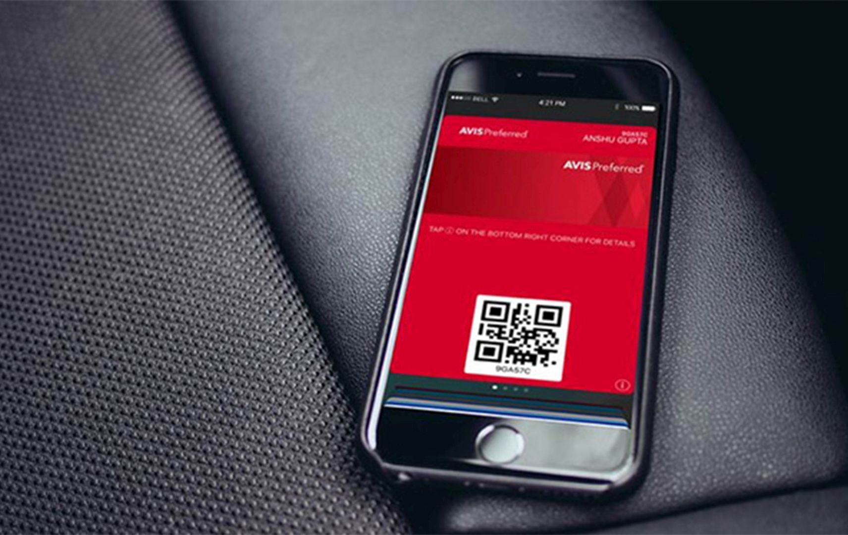 Smartphone mit rotem Screen zu Avis Preferred auf schwarzem Autositz