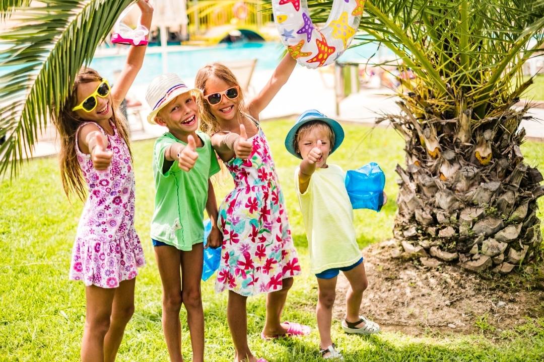 Kinder unter einer Palme im Urlaub