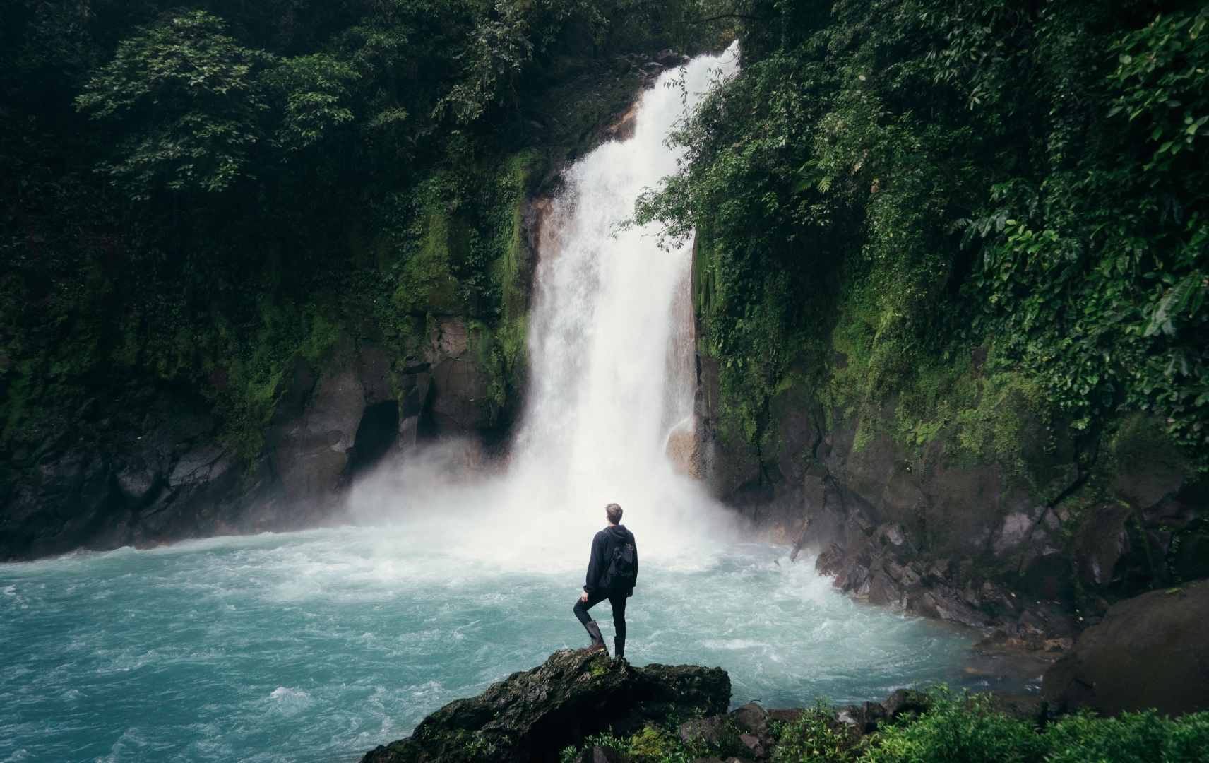 Mann an Wasserfall in Costa Rica