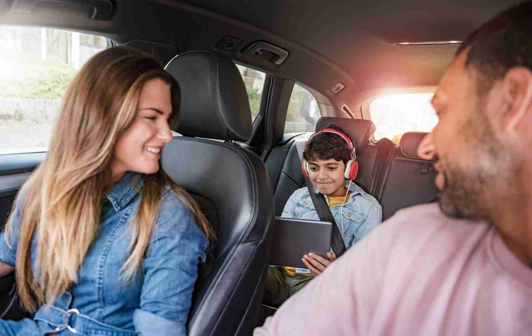 Eltern mit Kind im Auto zum Familienurlaub