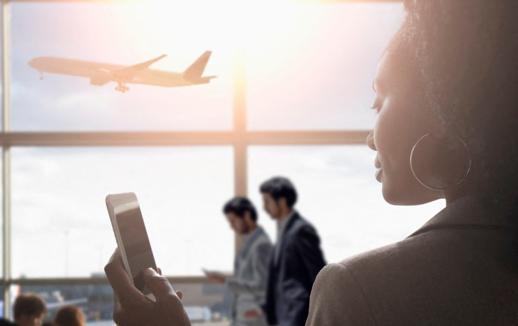 Frau mit Smartphone am Airport und Flugzeug im Hintergrund