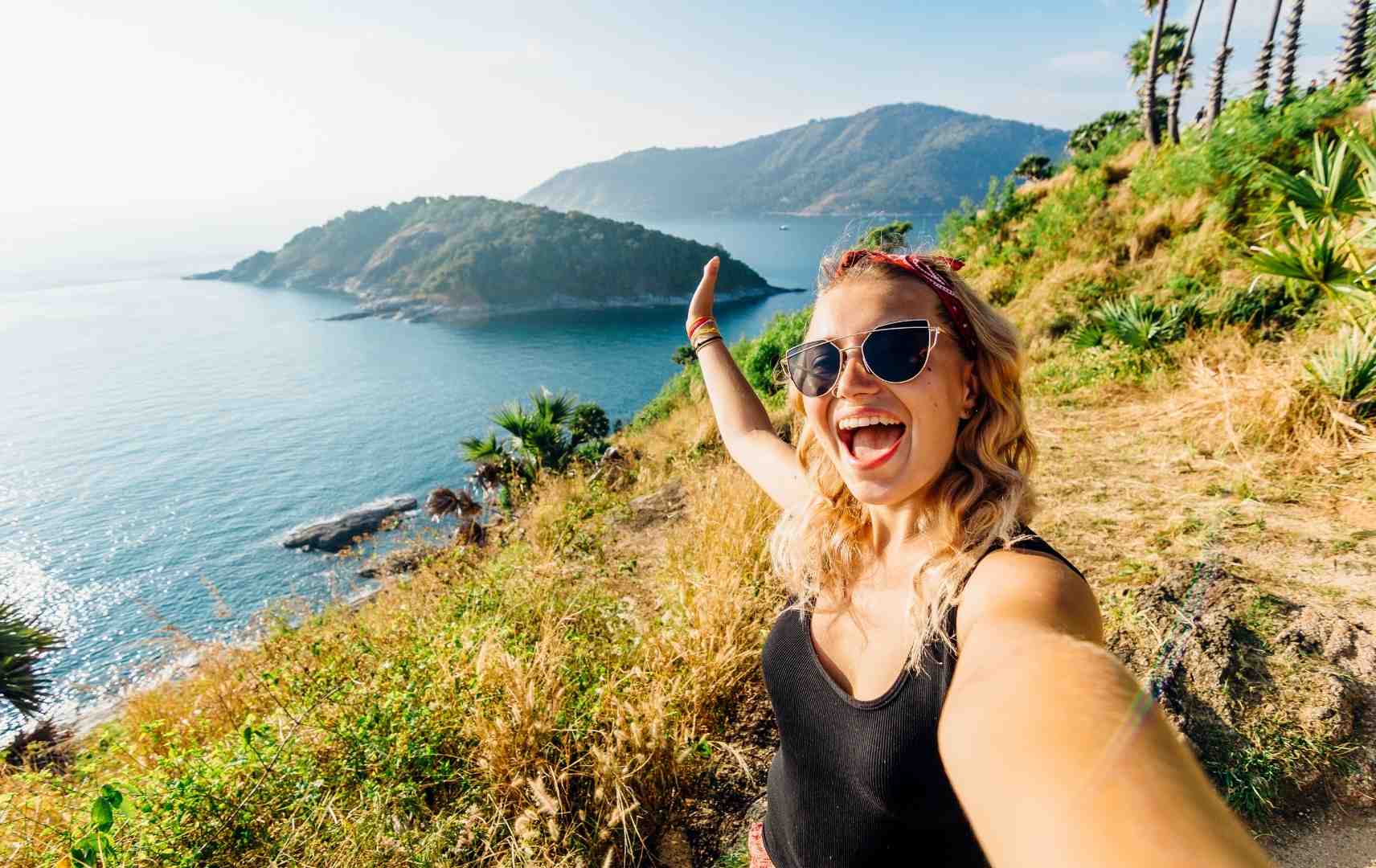 Frau macht Selfie mit Blick aufs Meer