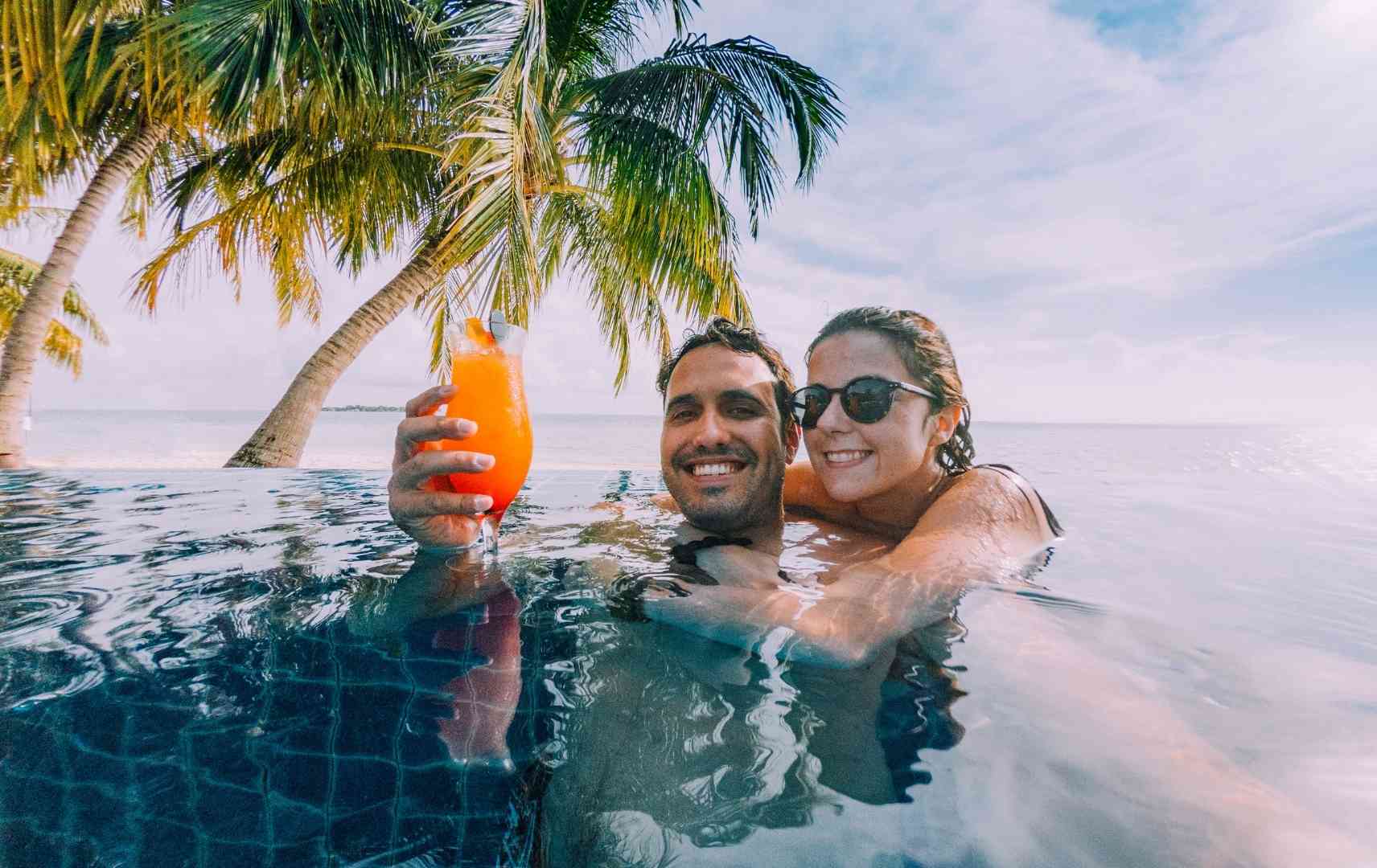 Paar genießt Cocktail im Pool