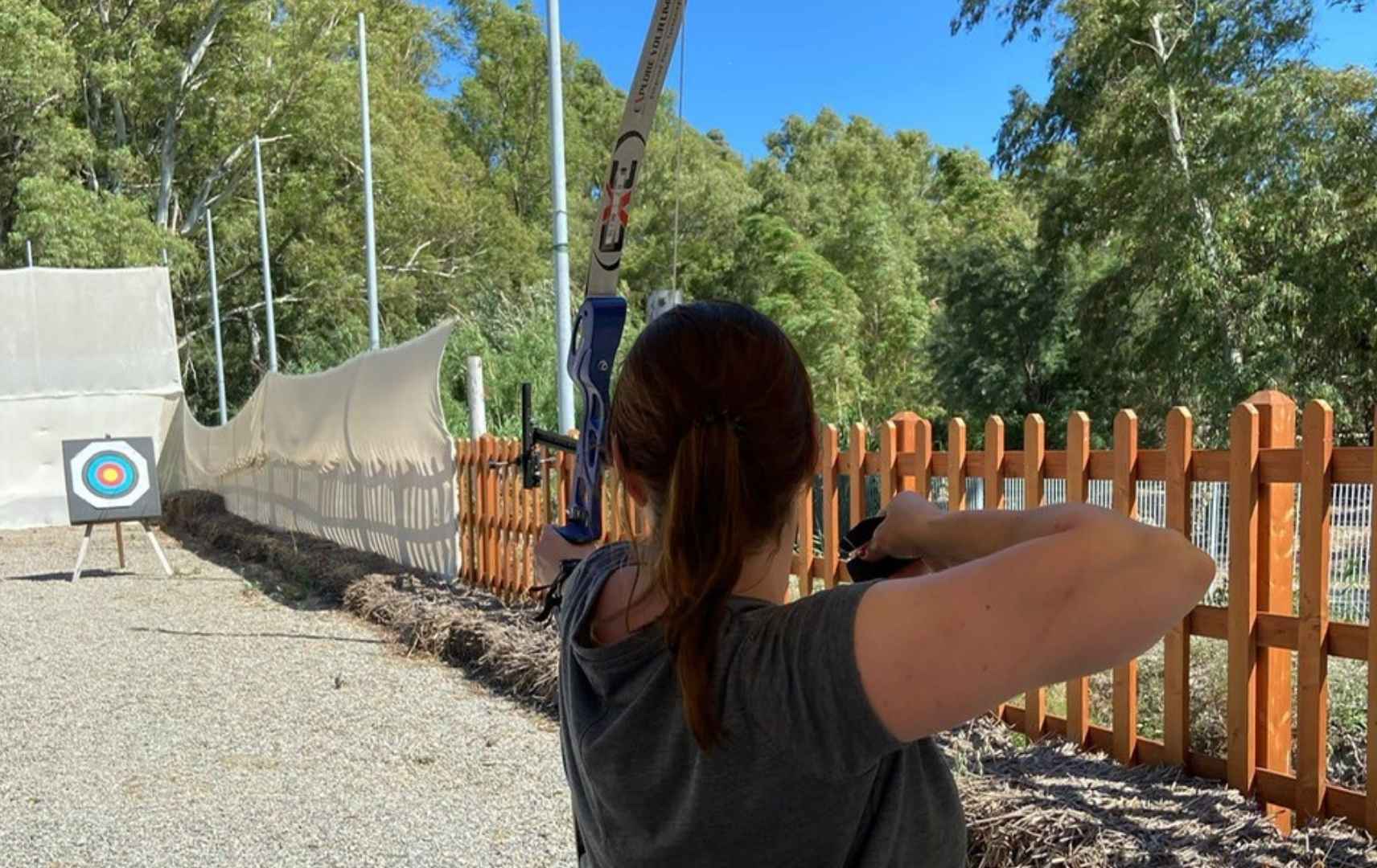 Frau schießt mit dem Bogen auf eine Zielscheibe