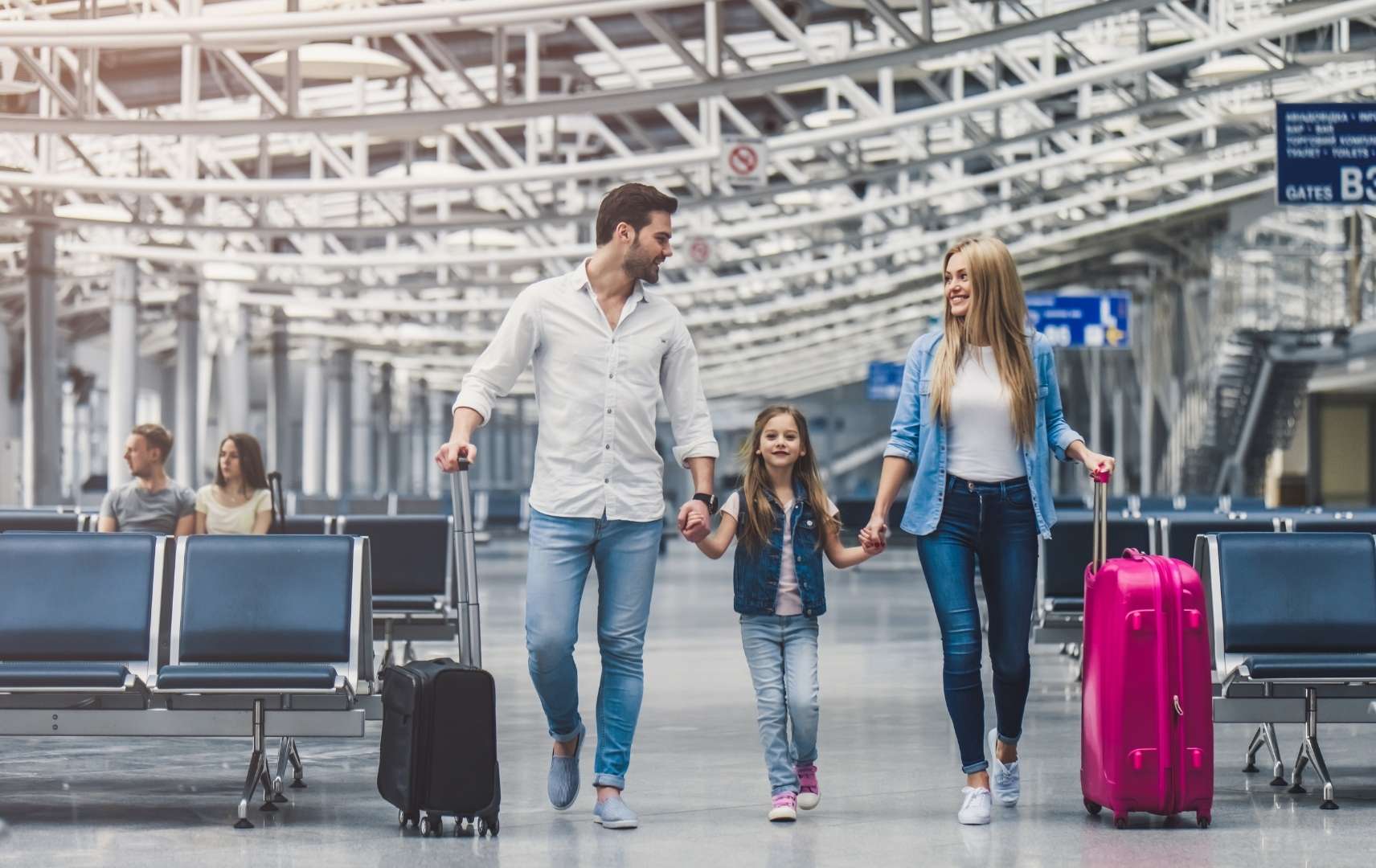 Glückliche Familien mit Koffern am Flughafen