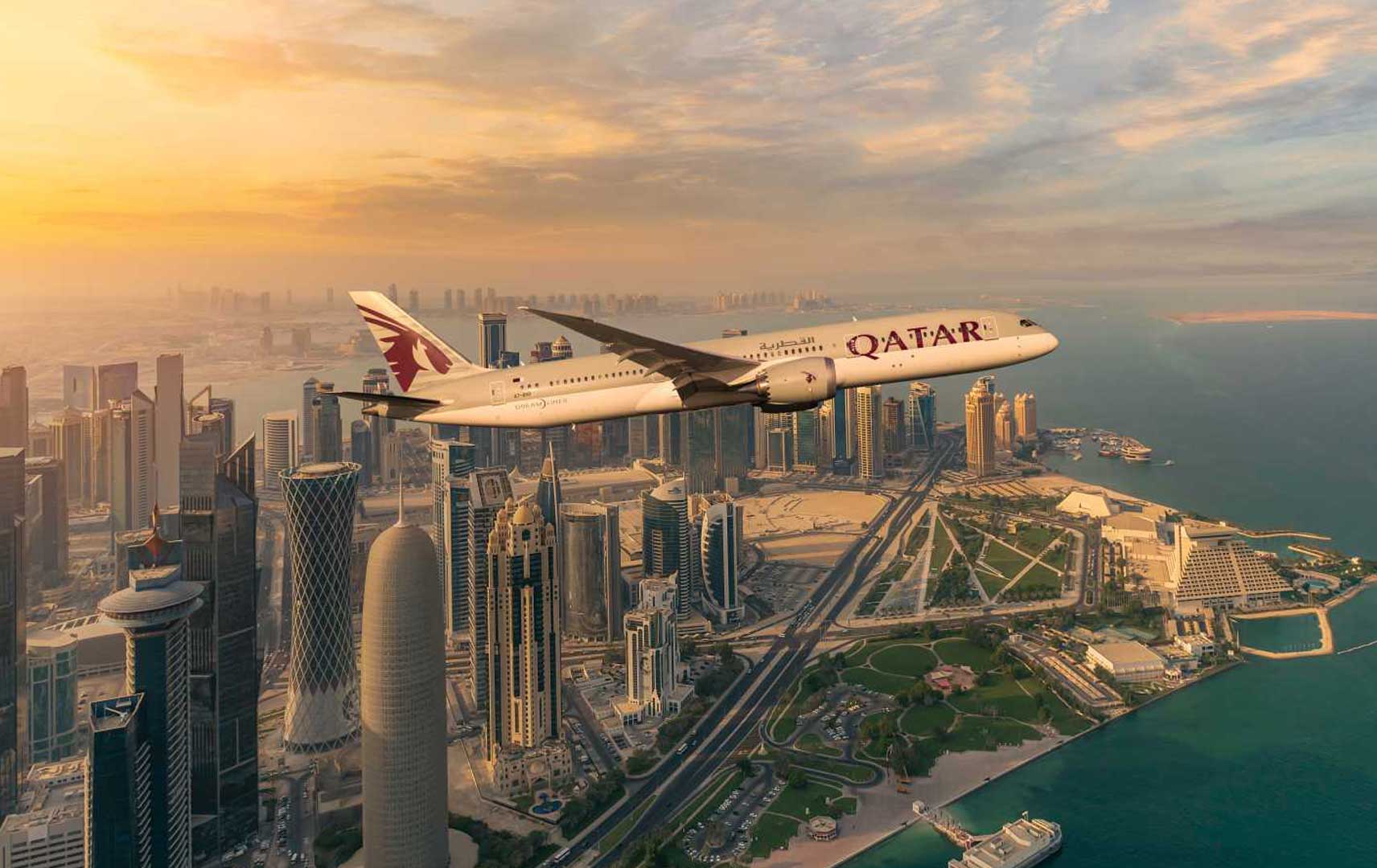 Flugzeug vn Qatar Airways vor Skyline in Doha