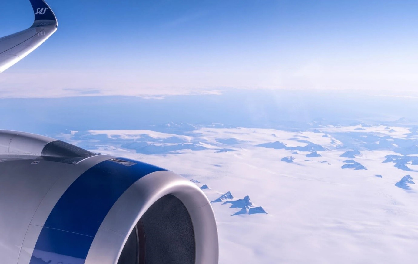 SAS Scnadinavian Airlines Triebwerk und Flügel am Himmel über schneebedeckten Bergen