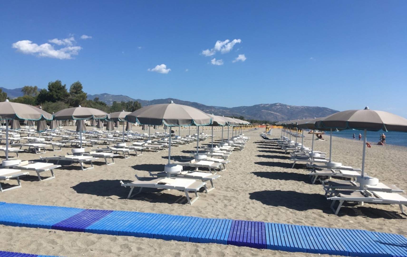 Strandabschnitt mit Liegen und Schirmen des Aldiana Clubs Calabria