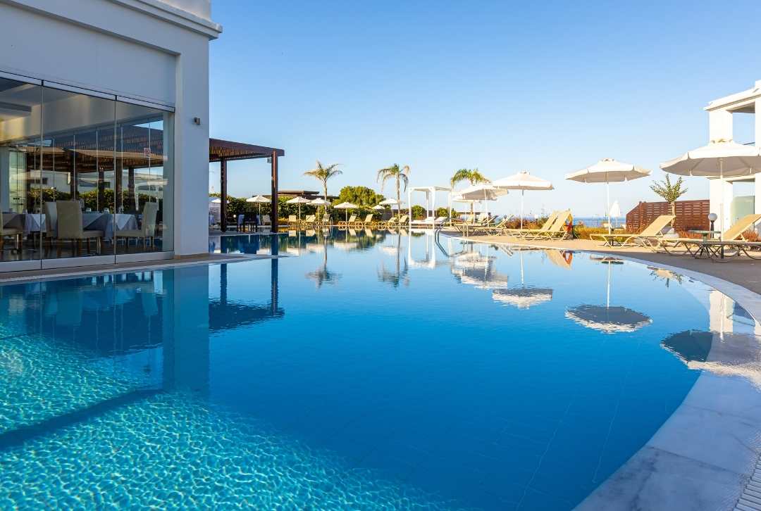 Pool mit Palmen und Schirmen im Sentido Asterias Beach Resort
