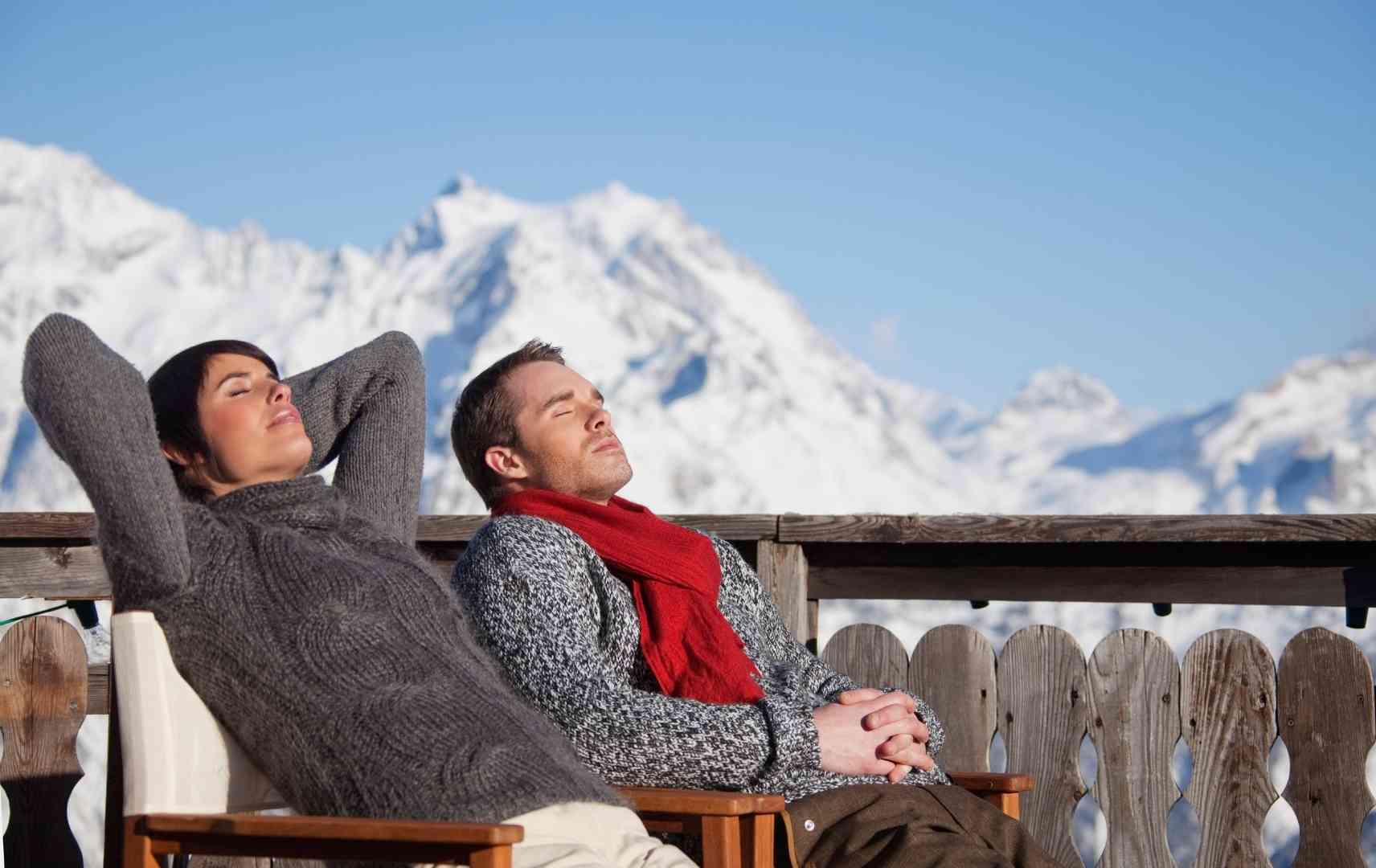 Paar genießt die Wintersonne in den Bergen
