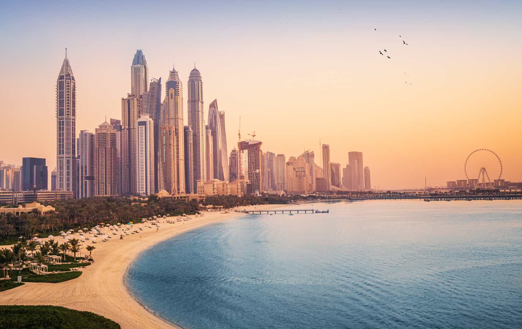 Sonnenuntergangsblick auf die Dubai Marina und das JBR-Gebiet und das berühmte Riesenrad und die goldenen Sandstrände im Persischen Golf.