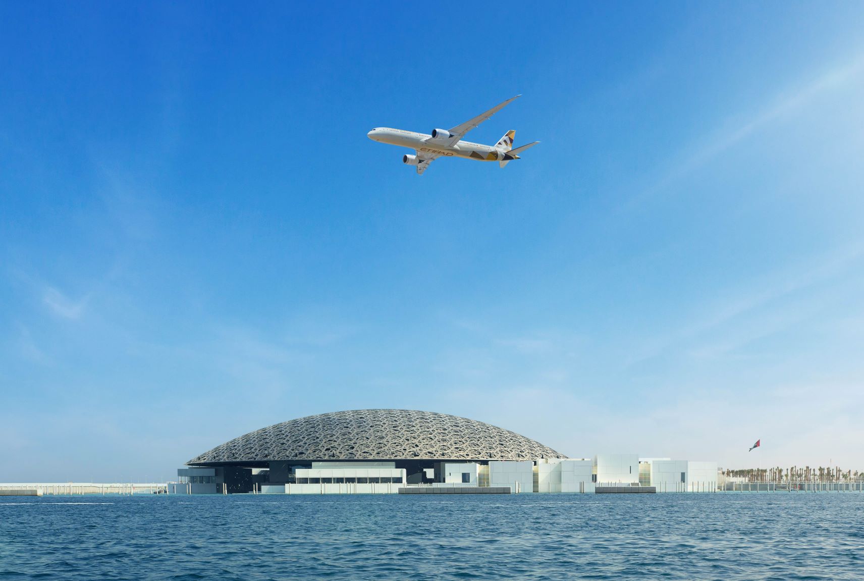 Maschine von Etihad Airways fliegt über den Louvre in Abu Dhabi