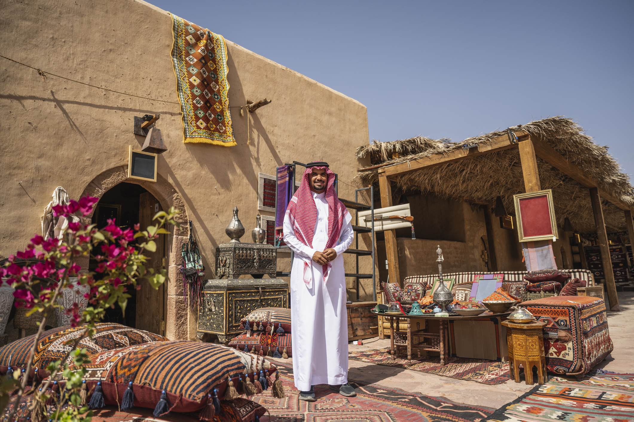 Saudischer Händler steht im Freien mit Produkten zum Verkauf